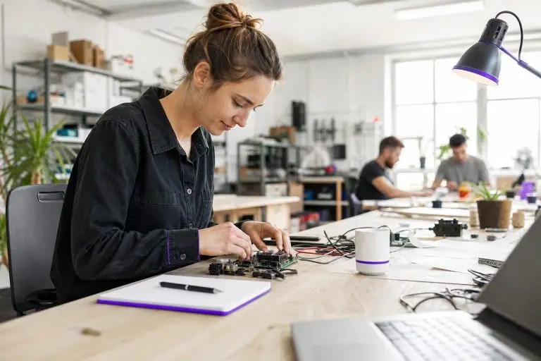 A woman working on electronic components in an office.