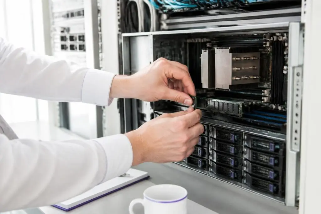 A person installing hardware in a server rack.