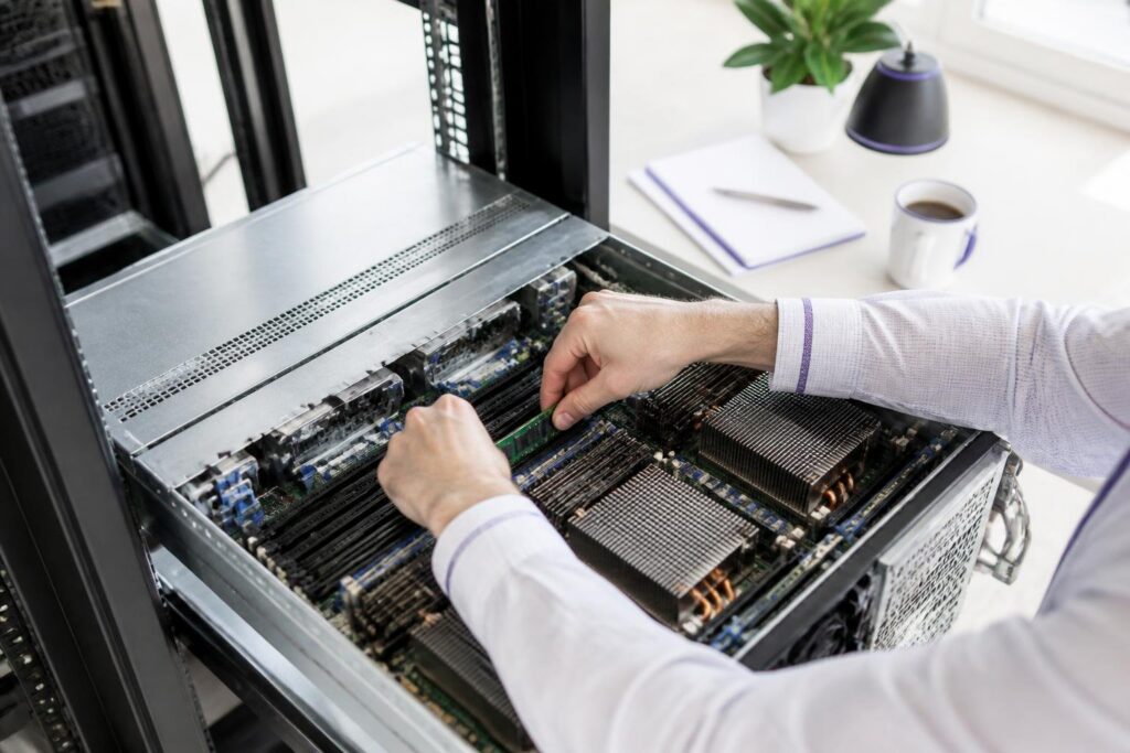 A person is working on an open server in a bright room.