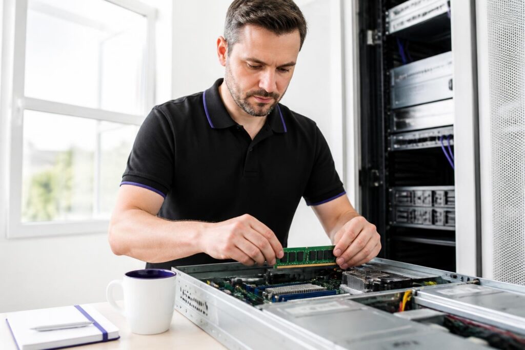 A man is working on a server in a bright room.
