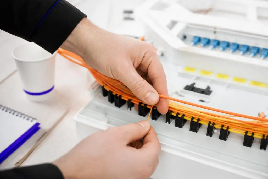 A person is working with cables in a distribution box.