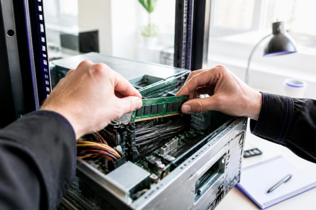 A person is installing RAM in a computer case.